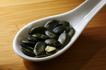 pumpkin seeds on porcelain spoon
