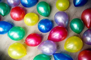 Inflatable multicolored balls lie on the white floor on holiday