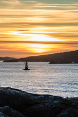 Fototapeta premium Orange and yellow sky above harbor port coast sunset sailing boat