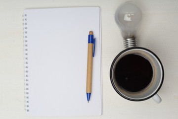 Notepad without text with a pen, coffee and great idea how grow up business. Business concept. On a white background. Horizontally.