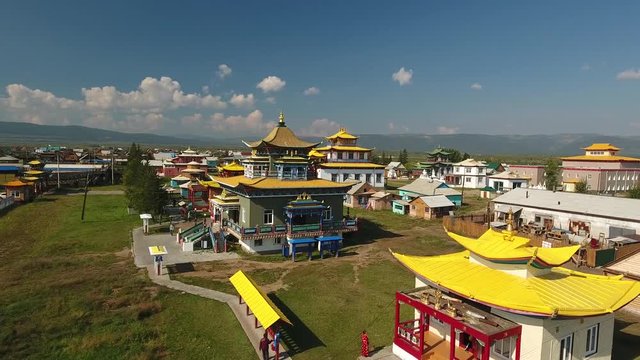 Ivolginsky Datsan Buddhist Monastery Russia Siberia Ulan-Ude Old complex temples  Monument History Architecture Multicolored buildings. People monk walk high mountains. Sunny day. Aerial Flight over
