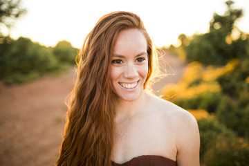 Beautiful brunette lady in wheat field at sunset