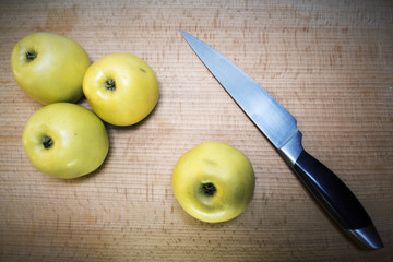 Cutting apples with a kitchen knife on a wooden board