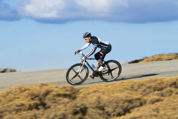 Fototapeta na wymiar Cyclist man riding mountain bike on a mountain road