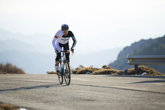 Cyclist man riding mountain bike on a mountain road