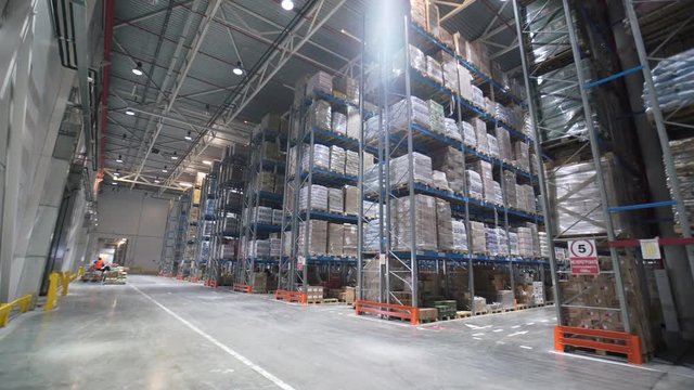 Industrial warehouse with boxes. Forklift Small cargo truck drives to warehouse. Large warehouse logistics terminal.
