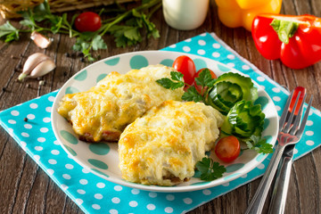 Potato casserole with meat in French on the kitchen table with fresh vegetables.