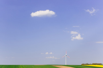 Fototapeta na wymiar Wind farm with spinning wind turbine