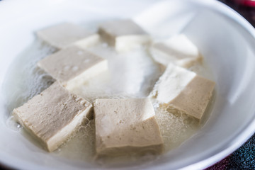 Tofu frying in ceramic pan