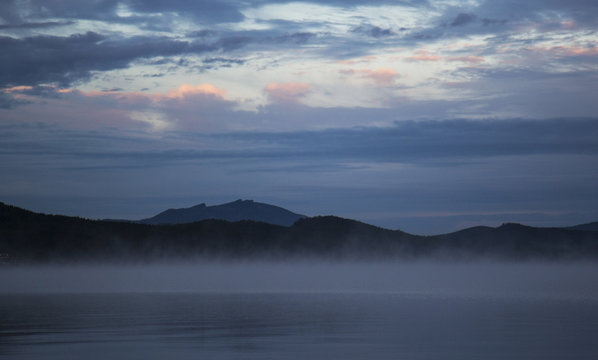 Borovoe lake during sunrise, sleeping knight mountain and smoke on the water, Burabay National park in Northern Kazakhstan.