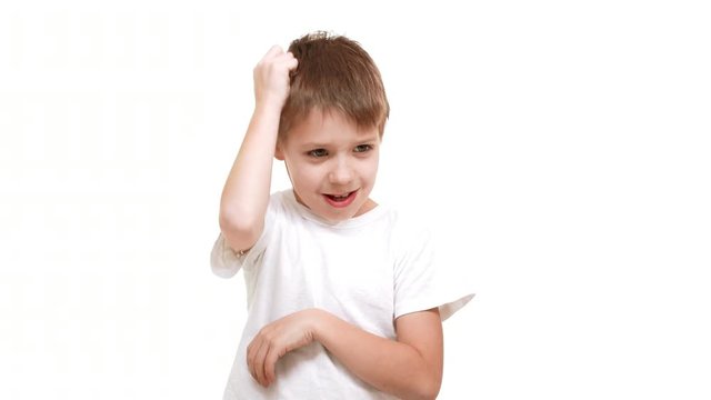 Young thoughtful elementary-school aged Caucasian boy scratching head and standing on white background