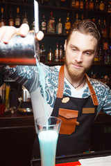 Steep bartender pours vodka in the bar