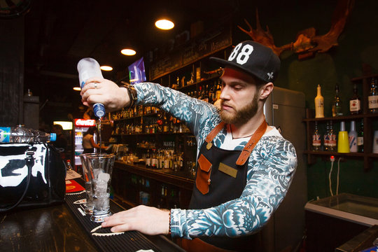 Steep bartender pours vodka in the bar
