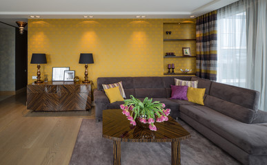 Modern decorated flat interior. Guest room. TV, tables, flowers, fruits.