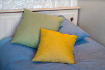 Three pillows. Yelow, green, blue.