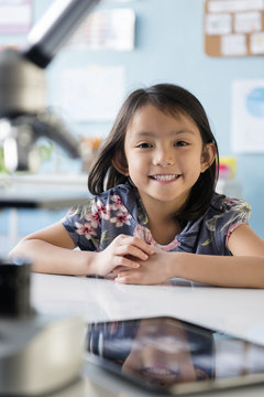 Smiling girl leaning posing at desk