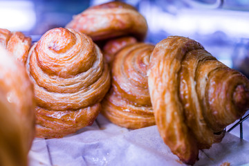 Macro closeup of glazed honey buns on display in bakery