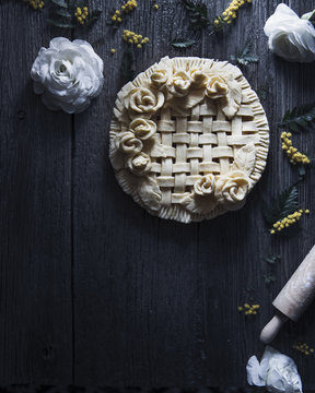 Overhead view of apple pie ready to bake placed on wooden table