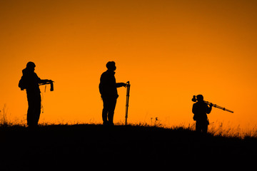 Silhouette of aphotographers top of mountain on sunset.