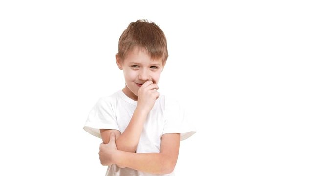 Concentrated Caucasian elementary-school aged boy standing on white background and then showing ok in slomotion