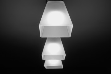 Three ceiling lamps in a room on a dark background focus