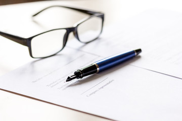 Signing the contract with pen and glasses in business work on office desk