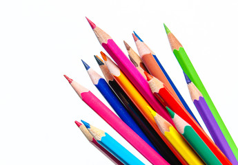 Many different colored pencils on paper background.