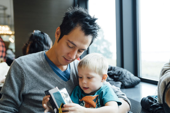 Mixed Race father and son reading menu in restaurant