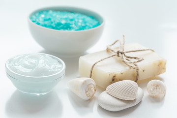 Fototapeta na wymiar sea salt, soap and body cream on white desk background