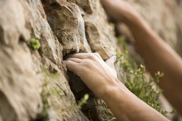 Gardinen Rock climber's hand grasping handhold on natural cliff. His hand is covered in chalk. Shallow depth of field. © juananbarros