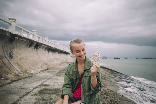 Caucasian woman holding shell at beach