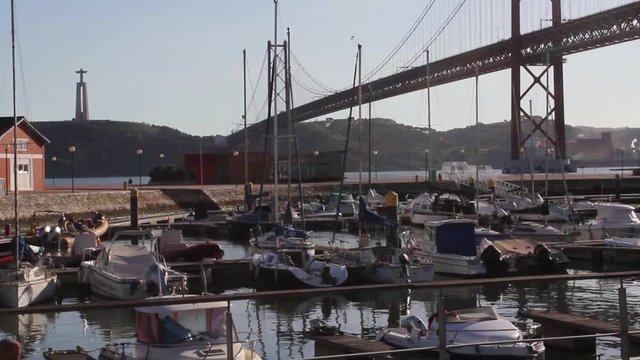Yachts moored at the marina of Doca de Santo Amaro under the Ponte 25 de Abril in the afternoon