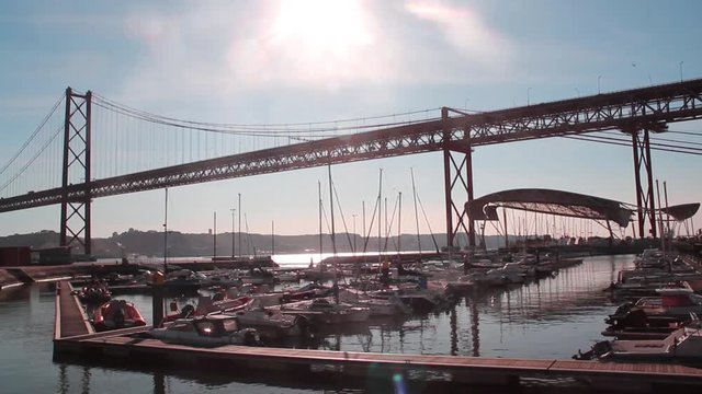 Yachts moored at the marina of Doca de Santo Amaro under the Ponte 25 de Abril in the afternoon