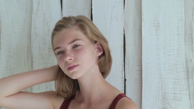 Portrait of pretty and sensual teen girl without makeup. White wooden background. Natural beauty concept