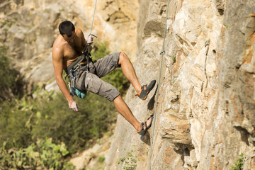 Naklejka premium Young man climbing on a wall