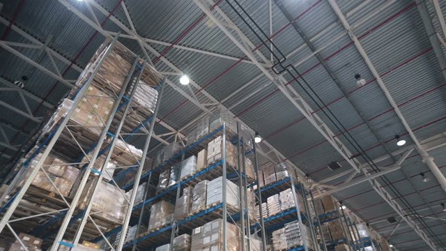 Camera moving between palettes with ordered goods and materials at warehouse. Large warehouse logistics terminal. Shot inside Logistic Store