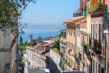 Steep streets of Lisbon with ocean in the background 