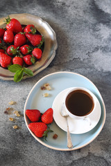 Raw red strawberries and cup of black coffee