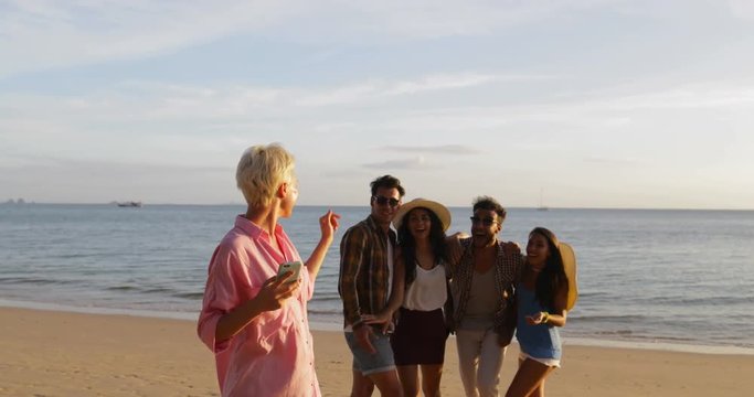 Girl Use Cell Smart Phone Welcome People Group To Take Selfie Photo On Beach, Happy Smiling Man And Woman Friends Slow Motion 60