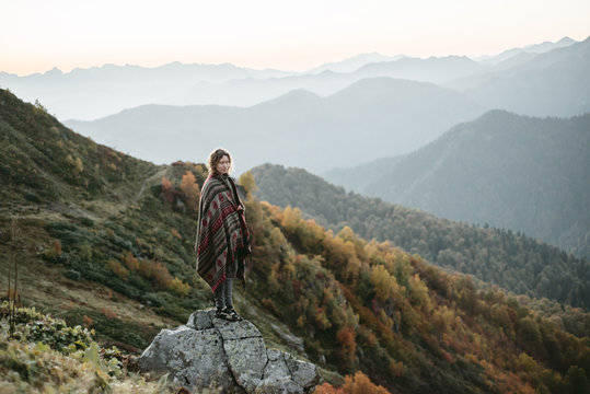 Caucasian woman standing on mountain rock overlooking valley