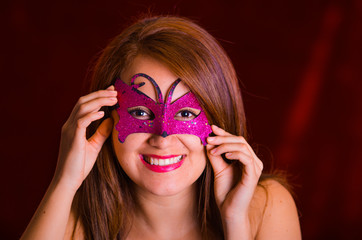 Portrain of beautiful model woman wearing pink carnival mask