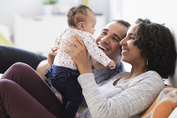 Hispanic mother and father playing with baby daughter