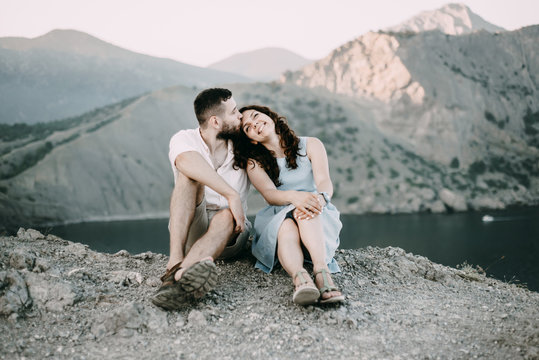 Caucasian man kissing woman on forehead at lake