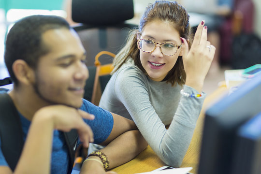 Mixed Race boy and girl using computer in library