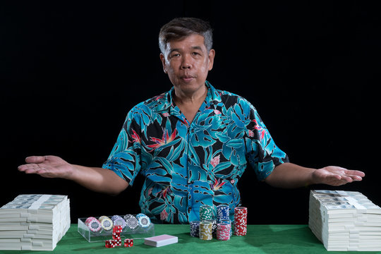 Rich man with stack of banknote and chips in casino