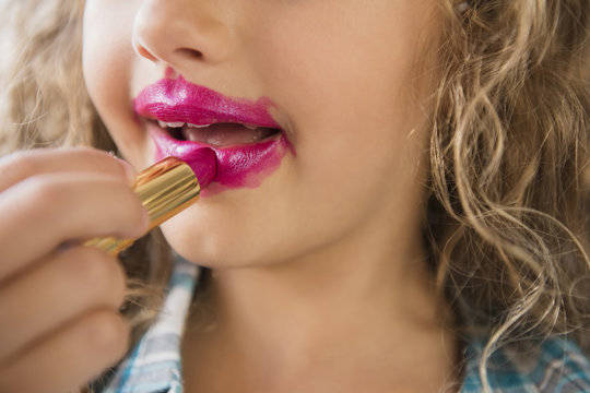 Caucasian girl applying messy lipstick