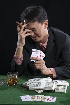 The gambler used finger grip a cigarette and hand off the face with the stress when he defeat