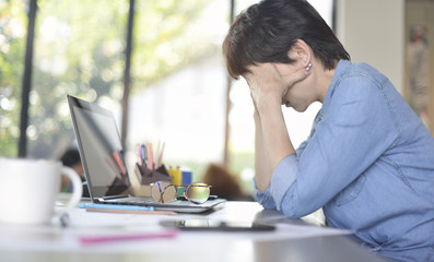 Tired businesswoman in office with laptop computer