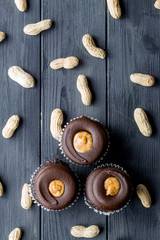Chocolate cupcakes filled with peanut butter and topped with chocolate mousse. Homemade bakery. Rustic background.
