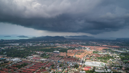 Top view of building and house of Phuket province in town area and view of dark clouds before raining. Aerial view from flying drone